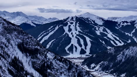 Ski-runs-trails-Distant-i70-Copper-Mountain-Leadville-Colorado-Winter-December-Christmas-aerial-drone-cinematic-landscape-Silverthorne-Vail-Aspen-Ten-Mile-Range-cloudy-Rocky-Mountains-right-circle