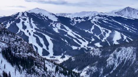over-i70-aerial-drone-cinematic-Copper-Mountain-Leadville-Colorado-Winter-December-Christmas-Ski-runs-trail-Distant-landscape-Silverthorne-Vail-Aspen-Ten-Mile-Range-cloudy-Rocky-Mountain-circle-right