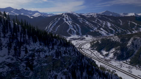 Copper-Mountain-Colorado-Winter-December-Christmas-aerial-drone-cinematic-landscape-i70-Leadville-Silverthorne-Vail-Aspen-Ten-Mile-Range-blue-sky-clouds-forward-past-Rocky-Mountains-reveal-motion
