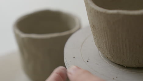 Fingers-turn-a-wheel-of-a-clay-cup's-form,-close-up-glimpse-into-an-artisan's-magical-creation