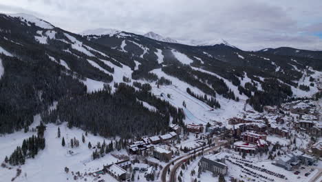 Parking-lot-base-half-pipe-big-air-Jump-ski-snowboard-gondola-ski-lift-aerial-drone-cinematic-Copper-Mountain-base-Colorado-Winter-December-Christmas-Ski-runs-trails-landscape-circle-left