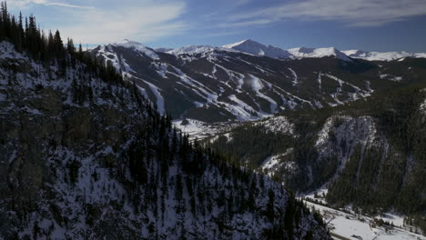 Ski-runs-Copper-Mountain-Colorado-Winter-December-Christmas-aerial-drone-cinematic-landscape-i70-Leadville-Silverthorne-Vail-Aspen-Ten-Mile-Range-blue-sky-clouds-past-Rocky-Mountains-right-zoom
