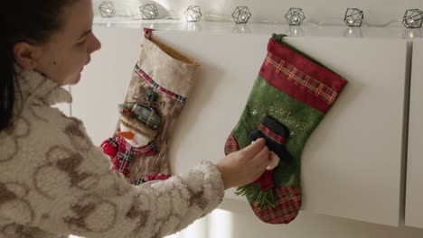 A-Woman-Is-Fixing-A-Hanging-Christmas-Stocking-Decor