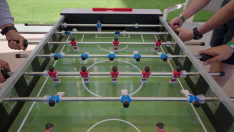 foosball-competition-between-young-men-in-the-hall-insert-shot,-push-in-shot,-push-out-shot