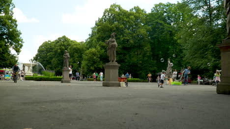 Park-with-statues-and-a-fountain,-people-and-bubbles---Saxon-Garden,-Warsaw
