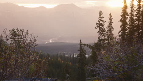 Nebliger-Sonnenaufgang-über-Einer-Ruhigen-Berglandschaft-Mit-Leuchtender-Sonne,-Bäumen-Und-Wasserfall