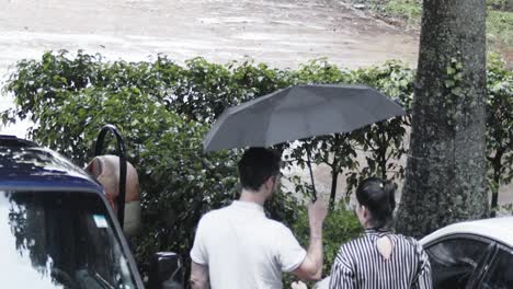 Gentleman-offers-space-under-umbrella-to-partner-as-rainfall-descends