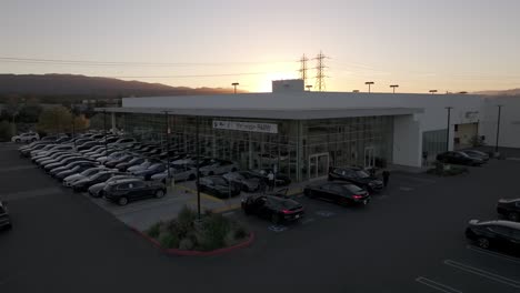 BMW-Dealership-with-lot-full-of-luxury-cars---aerial-flyover-at-sunset