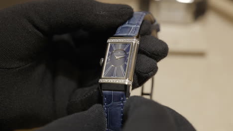 Classy-luxury-watch-held-by-person-with-black-gloves,-close-up