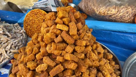 Rotating-shot-of-delicious-traditional-fried-sweets-on-display-at-a-roadside-stall-on-a-cold-winter-day-in-Kolkata,-India