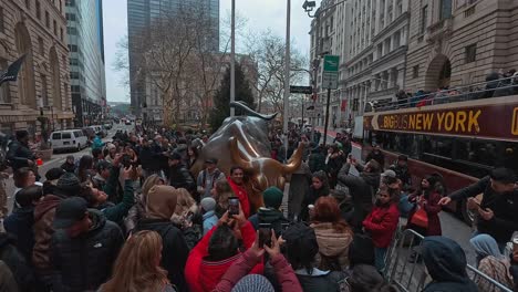 People-gathered-around-the-charging-bronze-bull-on-wall-street-in-the-financial-district-of-New-York-City