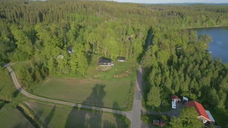 Lange-Schatten-Des-Hohen-Waldes-Am-Ufer-Des-Sees-Verbergen-Malerische-Ferienhäuser-Im-Malerischen-Ilerasasjön-See,-Schweden