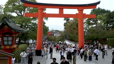 Geschäftige-Menschenmassen-Laufen-Am-Zweiten-Torii-Tor-Vorbei-Zum-Eingang-Des-Turmtors-Zur-Fushimi-Inari-Taisha-In-Kyoto