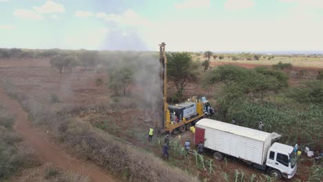 Drilling-truck-in-search-of-drinkable-water-in-African-farmland,-aerial