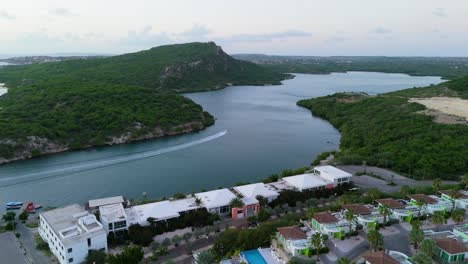 Boat-drives-up-winding-channel-into-Piscadera-harbor-Curacao-at-dawn