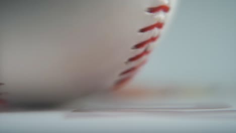 Cinematic-macro-shot-of-a-rotating-white-base-ball,-close-up-on-red-stitches,-baseball-rotate,-professional-studio-lighting,-smooth-slow-motion-120-fps-close-up