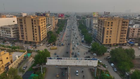 Drohnenaufnahme-Der-Stark-Befahrenen-Shaheed-e-Millat-Straße-Während-Des-Sonnenuntergangs-In-Karatschi,-Pakistan