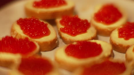 Sandwich-slices-with-butter-and-red-roe-fish-caviar-handheld-closeup