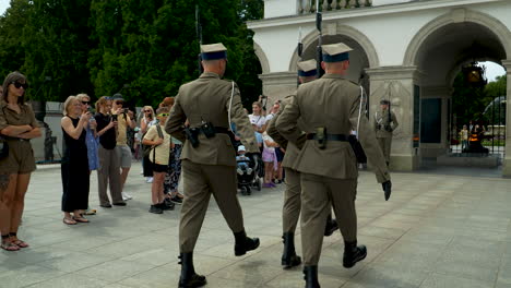 Soldados-Con-Rifles-Vistos-Desde-Atrás,-Espectadores-Con-Cámaras---Tumba-Del-Soldado-Desconocido-En-Varsovia,-Polonia