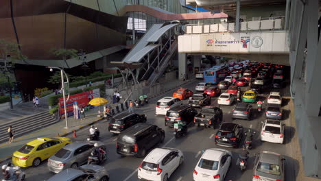 Un-Tráfico-Muy-Congestionado-Frente-A-Un-Centro-Comercial-En-El-Centro-De-La-Ciudad-De-Bangkok,-Tailandia