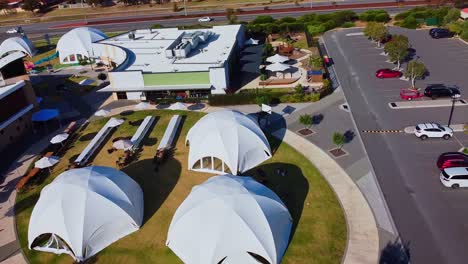 Aerial-orbit-view-over-white-dome-event-tents-setup-ready-for-outdoor-gathering
