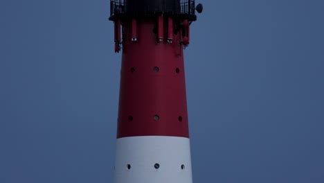 Slow-tilt-shot-of-working-lighthouse-at-night