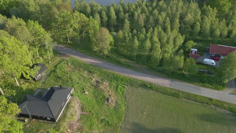 Cinematic-aerial-dolly-tilt-up-reveals-vacation-home-and-stunning-Illerasasjon-Lake,-Sweden-at-midday