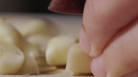 Chef's-Hand-Cutting-Fresh-Peeled-Garlic-With-A-Knife