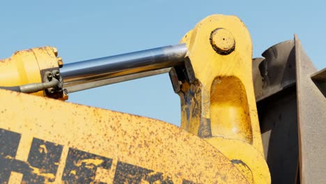 Hydraulic-arm-of-digger-moving-bucket-loader-while-working-on-construction-site,-close-up