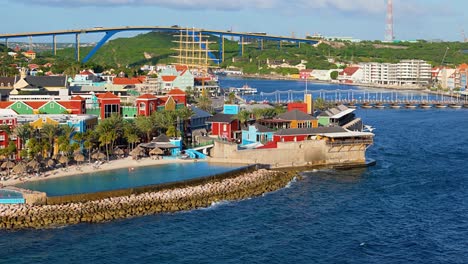 Luftschwenk-über-Das-Einkaufszentrum-Und-Den-Infinity-Pool-Des-Hotels-Unterhalb-Der-Queen-Juliana-Brücke-In-Willemstad,-Curacao