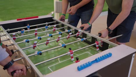 foosball-competition-between-young-men-in-the-hall-insert-shot,-close-up-shot