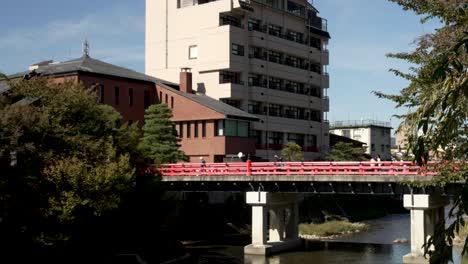Nakabashi-Brücke-über-Den-Miyagawa-Fluss-In-Takayama-An-Einem-Sonnigen-Nachmittag-Mit-Menschen,-Die-Darüber-Laufen