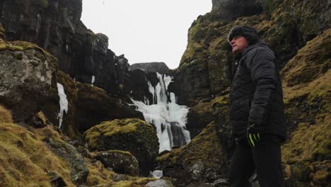 Tourist-enjoy-Iceland-volcanic-mountain-valley-near-scenic-waterfall