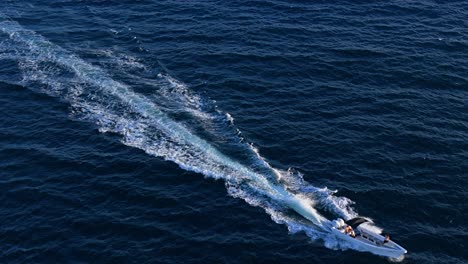 Ein-Fischerboot-Hinterlässt-Große-Weiße-Kielwasser,-Während-Es-über-Das-Offene-Meer-Fährt