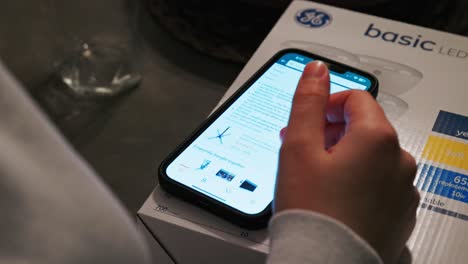 A-woman-scrolls-through-the-screen-of-a-smart-phone