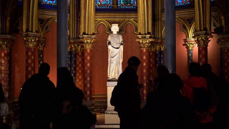 Beleuchtete-Statue-Isoliert-Zwischen-Schwarzen-Silhouetten-Von-Touristen-In-Der-Oberen-Kapelle-Der-Sainte-Chapelle-In-Paris,-Frankreich