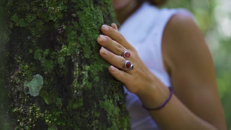 Weibliche-Hand-Mit-Ringen-Und-Armbändern,-Die-Die-Energie-Des-Baumes-Und-Der-Natur-Im-Wald-Streichelt-Und-Sich-Mit-Ihr-Verbindet