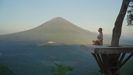 Woman-on-platform-breathing-technique-for-stress-relief-with-Mount-Agung-in-background