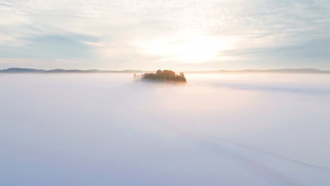 A-small-island-or-isle-in-middle-of-a-frozen-lake-or-sea-ice-engulfed-in-fog-or-mist