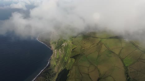 Flying-through-low-clouds-above-flores-island-in-Azores,-aerial
