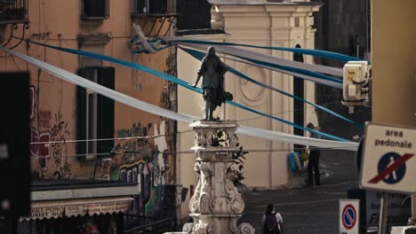 Graffiti-lined-street-with-statue,-Naples