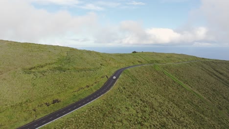 Following-shot-of-car-driving-at-mountain-road-in-Flores-Azores,-aerial