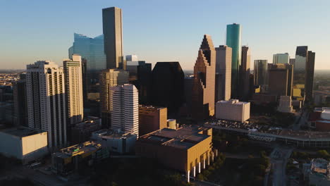 Aerial-view-around-the-sunlit-skyline-of-Houston,-dramatic-sunset-in-Texas,-USA