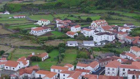 Drone-view-of-Fajã-Grande-town-with-waterfalls-in-background-in-Azores-Portugal