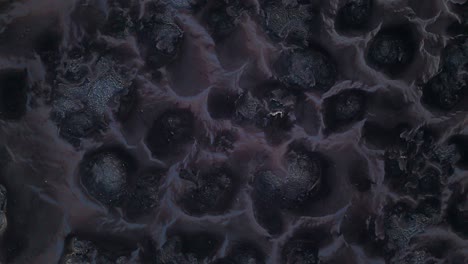 Zenithal-rotate-satellite-view-of-black-and-grey-mounds-of-polluted-toxic-waste-on-dry-landscape