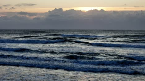 Dusk-settles-over-tumultuous-ocean-waves,-Cloud-lined-skies-above-the-twilight-sea