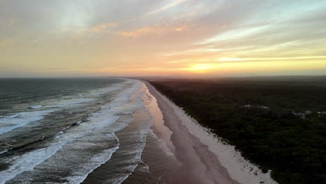 Der-Sonnenuntergang-Wirft-Einen-Warmen-Schein-über-Einen-Einsamen-Strand,-Die-Küste-Wird-Vom-Letzten-Licht-Des-Tages-Geschmückt