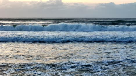 Golden-sunlight-reflecting-on-tumultuous-ocean-waves,-The-sea's-surface-glistening-at-sunset