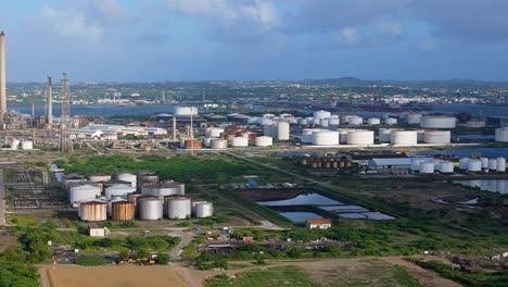 Large-storage-tanks-of-oil-refinery-line-up-in-rows-below-flare-stacks-in-Curacao