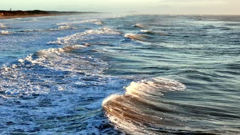 Schroffe-Wellen,-Die-Sich-Entlang-Eines-Riesigen-Strandes-Türmen,-Die-Dynamische-Schnittstelle-Von-Meer-Und-Land-Unter-Freiem-Himmel